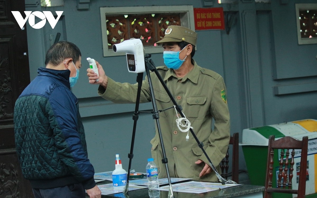 security forces are on duty from the site’s opening in order to record the body temperature of worshippers and to remind people of the need to use hand sanitizer at the ha pagoda in cau giay district.