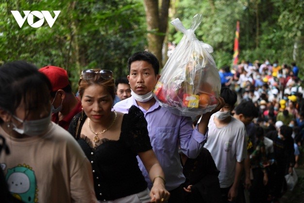 a family brings chicken, cakes, and various types of fruit as offerings to the hung kings.